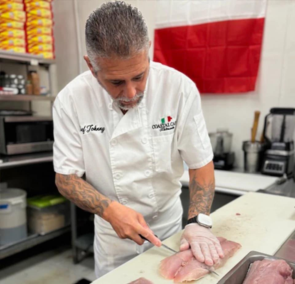Chef Johnny trimming meat by hand in the Coastal Capri kitchen